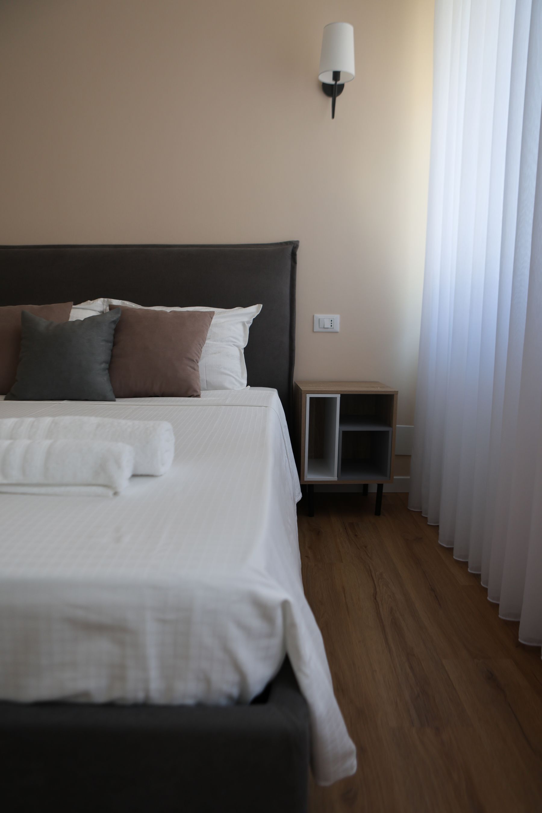 Letto matrimoniale con applique da parete e pavimento in legno