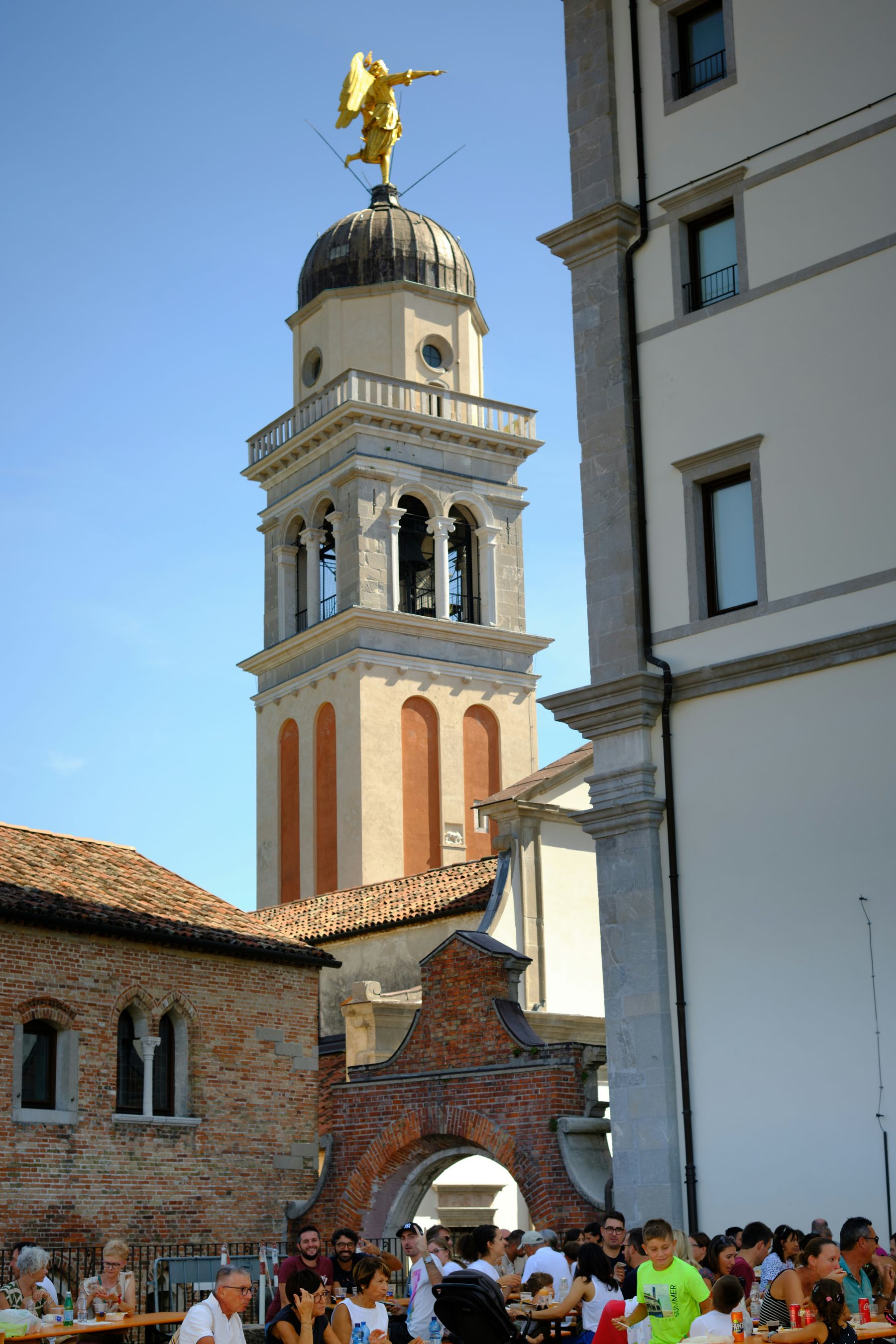 Il campanile con l'angelo dorato che domina la citta, visto durante una festa di paese